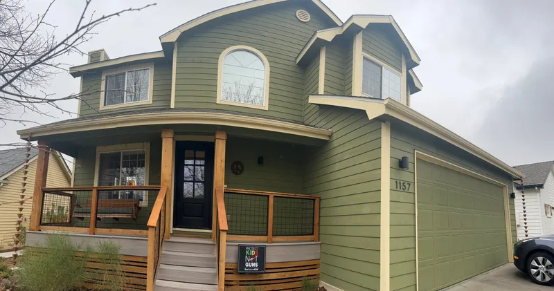 Green exterior house painting with cedar accents and porch in Fort Collins